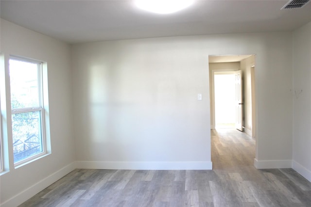 unfurnished room featuring hardwood / wood-style floors and plenty of natural light