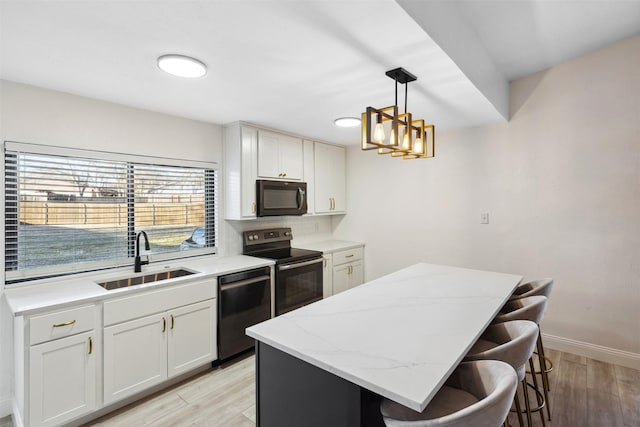 kitchen with white cabinets, a kitchen island, sink, and stainless steel appliances