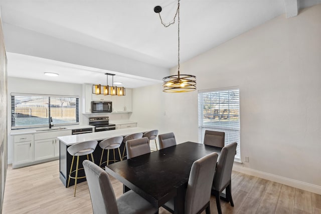 dining area featuring a chandelier, light wood-type flooring, and sink