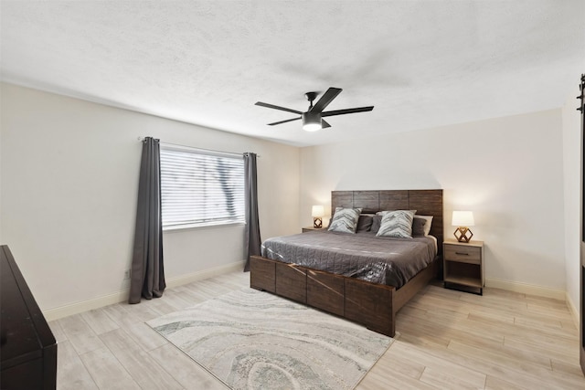 bedroom with a barn door and ceiling fan