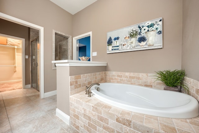 bathroom with shower with separate bathtub and tile patterned floors