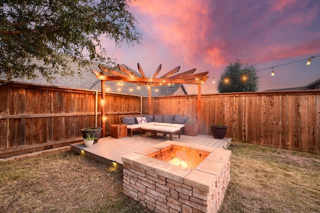 deck at dusk with a pergola and an outdoor living space with a fire pit