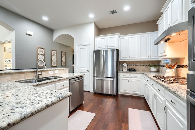 kitchen with white cabinets, appliances with stainless steel finishes, light stone counters, and sink