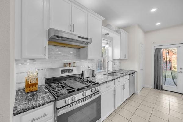 kitchen with dark stone countertops, white cabinetry, sink, and stainless steel appliances