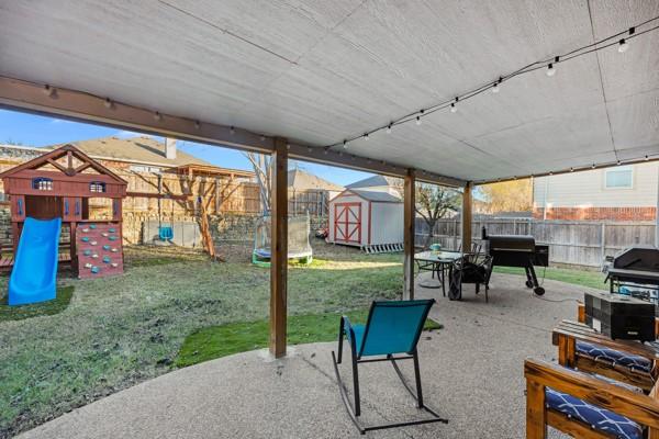 view of patio / terrace featuring a playground and a shed