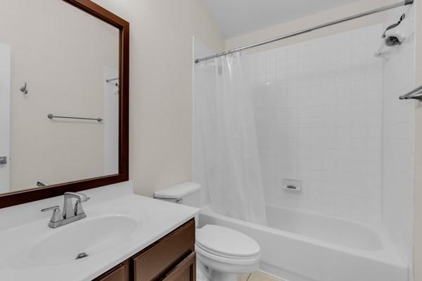 full bathroom with shower / bath combo, vanity, and toilet