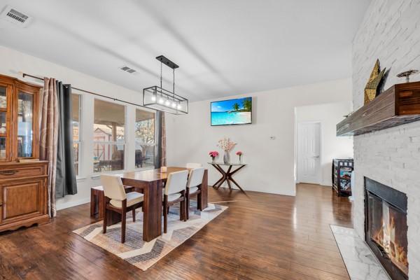 dining space featuring a large fireplace and dark hardwood / wood-style floors