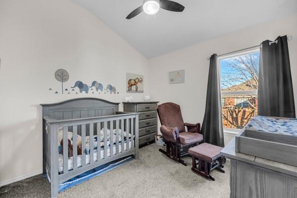 bedroom with ceiling fan, a crib, carpet floors, and lofted ceiling