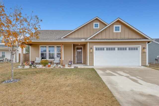 view of front of house featuring a front yard, a porch, and a garage