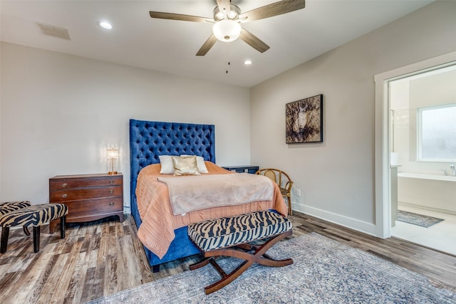 bedroom with ceiling fan, hardwood / wood-style floors, and ensuite bath