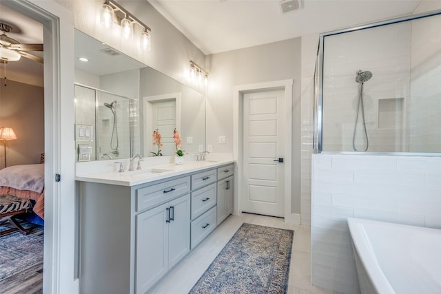 bathroom with ceiling fan, vanity, and separate shower and tub