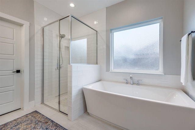 bathroom featuring tile patterned floors and shower with separate bathtub