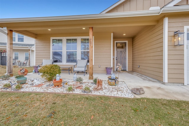 entrance to property featuring a patio area and a lawn