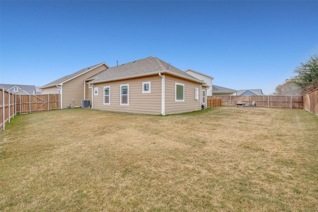 rear view of house featuring a yard and cooling unit