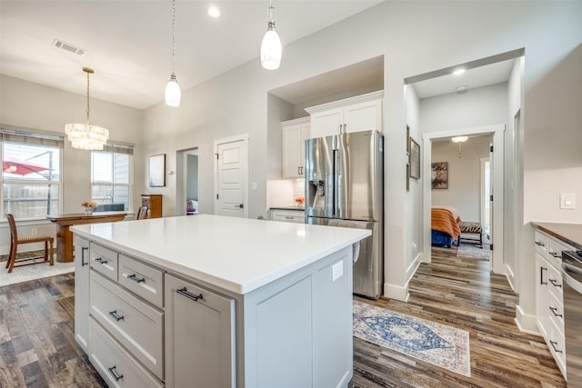 kitchen featuring white cabinetry, stainless steel refrigerator with ice dispenser, a kitchen island, and pendant lighting