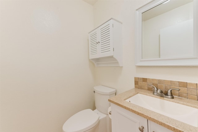 bathroom with vanity, toilet, and decorative backsplash