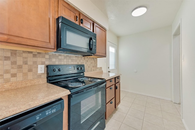 kitchen featuring backsplash, light tile patterned flooring, and black appliances