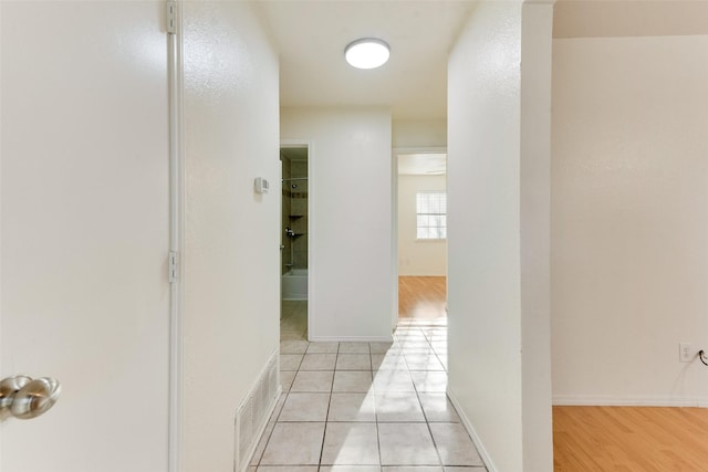 corridor featuring light tile patterned floors