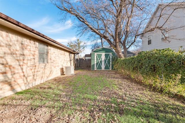 view of yard with central AC and a storage unit