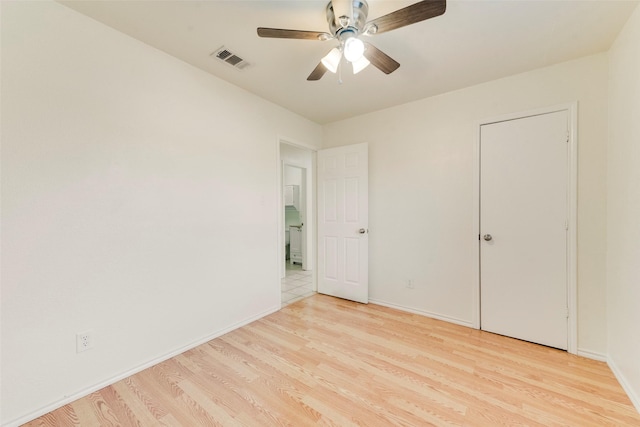 empty room with ceiling fan and light hardwood / wood-style floors