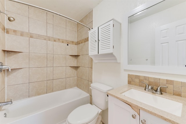 full bathroom featuring vanity, toilet, backsplash, and tiled shower / bath combo