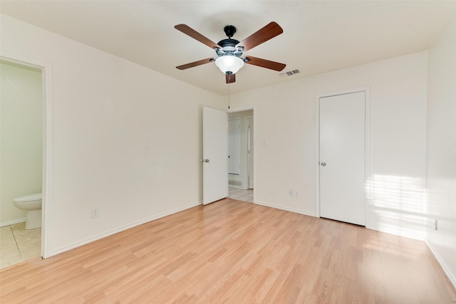 unfurnished bedroom with ensuite bathroom, ceiling fan, and light hardwood / wood-style flooring