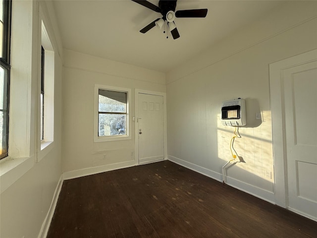 empty room with dark wood-type flooring, heating unit, and ceiling fan