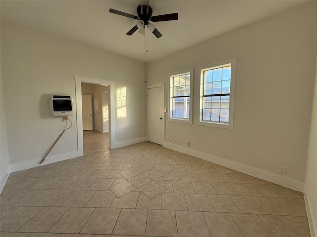 empty room featuring ceiling fan, heating unit, and light tile patterned floors