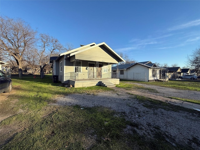 view of side of property with a yard and covered porch