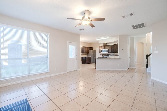 unfurnished living room with ceiling fan, light tile patterned flooring, and a wealth of natural light