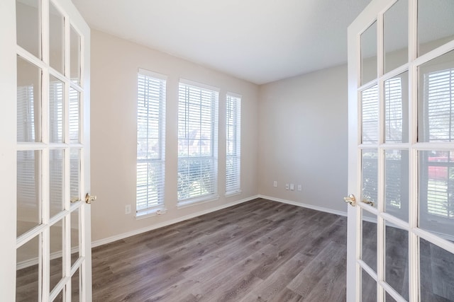 empty room featuring french doors and dark hardwood / wood-style flooring