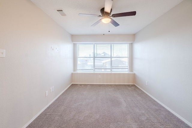 carpeted spare room with ceiling fan