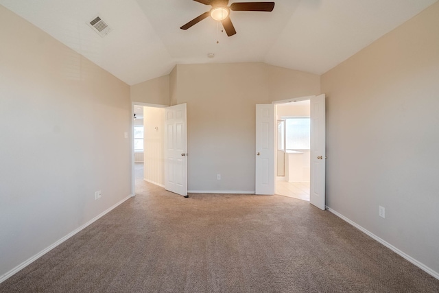 unfurnished bedroom with ceiling fan, multiple windows, light carpet, and vaulted ceiling