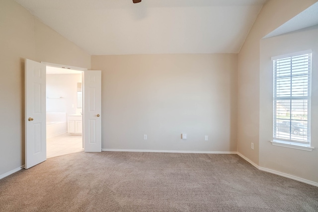 carpeted empty room featuring lofted ceiling