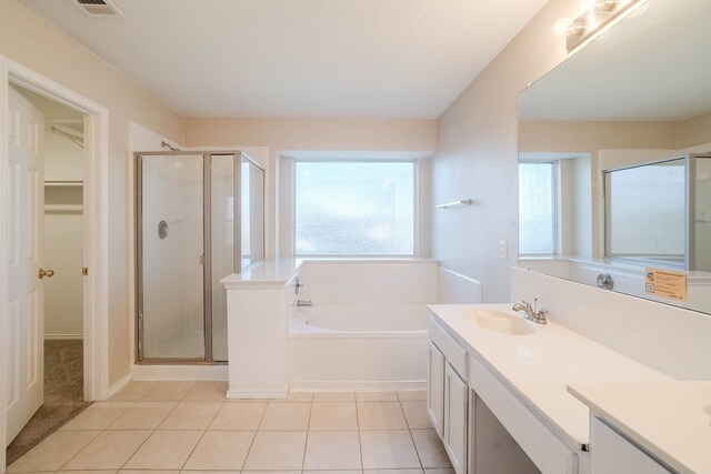 bathroom with tile patterned floors, vanity, a textured ceiling, and separate shower and tub