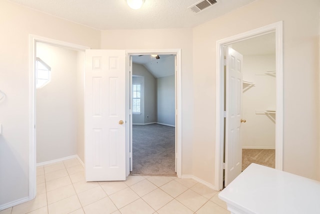 hallway featuring light carpet and a textured ceiling