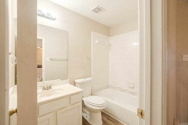 full bathroom featuring vanity, a textured ceiling, bathing tub / shower combination, wood-type flooring, and toilet