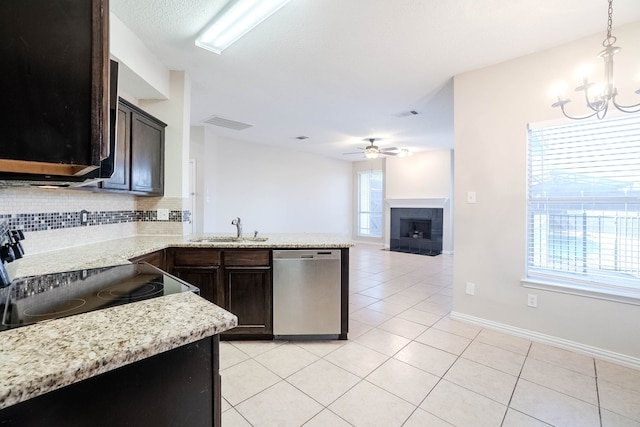 kitchen featuring sink, stainless steel dishwasher, stove, decorative light fixtures, and dark brown cabinets