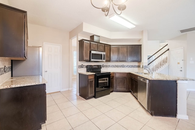 kitchen with light stone counters, dark brown cabinetry, kitchen peninsula, and stainless steel appliances