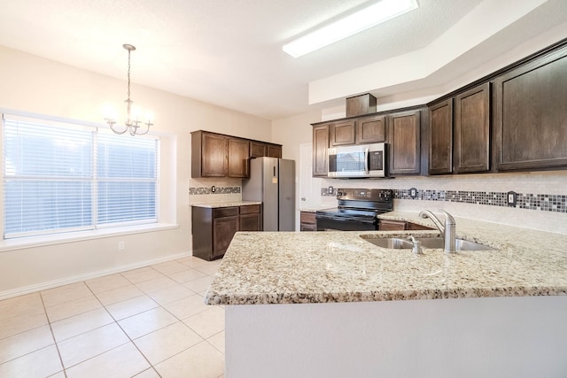 kitchen with sink, stainless steel appliances, light stone counters, pendant lighting, and dark brown cabinets