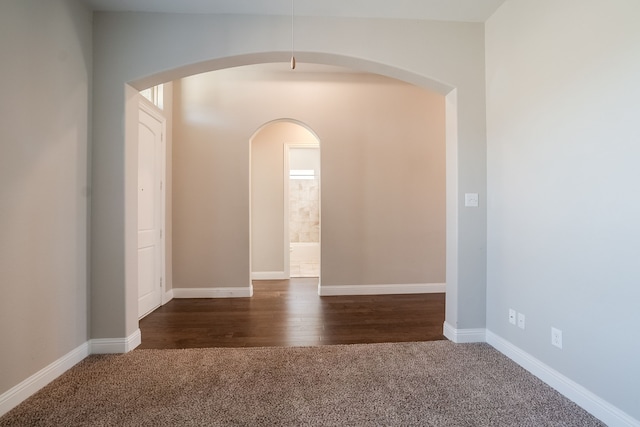 unfurnished room featuring dark colored carpet