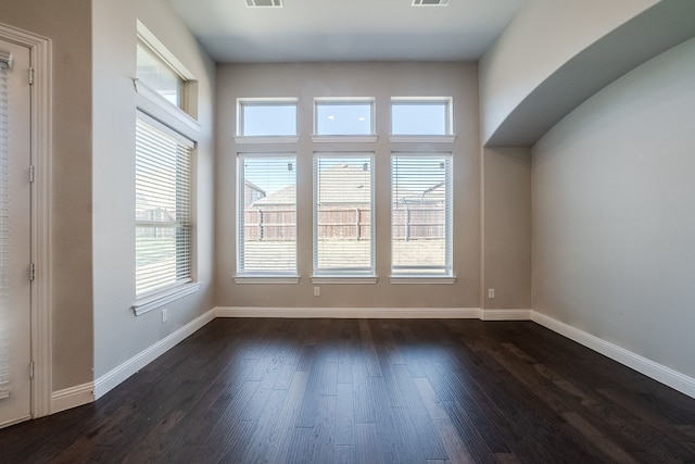 interior space with dark hardwood / wood-style flooring and plenty of natural light