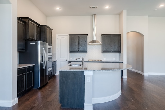 kitchen with backsplash, sink, an island with sink, appliances with stainless steel finishes, and light stone counters