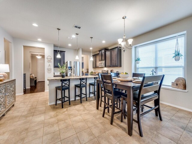 tiled dining area featuring a notable chandelier