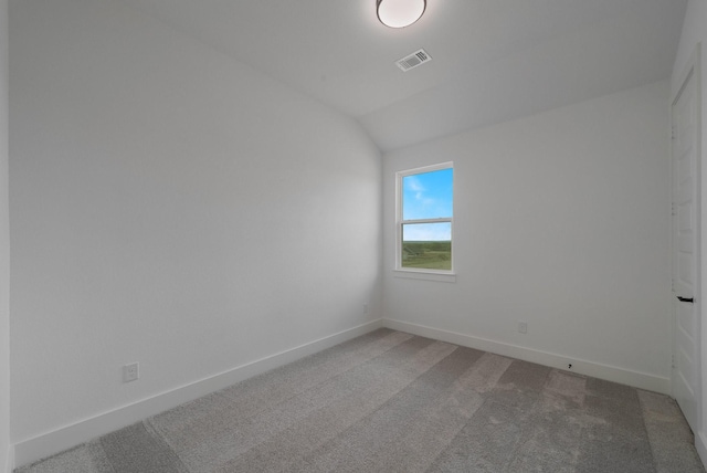 carpeted spare room with lofted ceiling