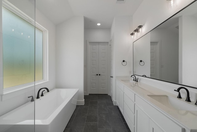 bathroom with vanity, tile patterned flooring, and a washtub