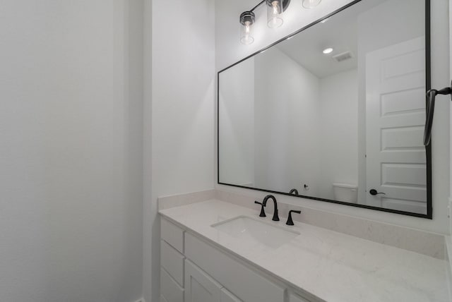 bathroom featuring vanity and toilet