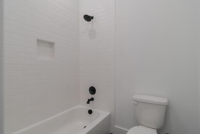 bathroom featuring tiled shower / bath and toilet