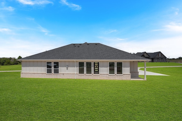 rear view of house featuring a yard and a patio area