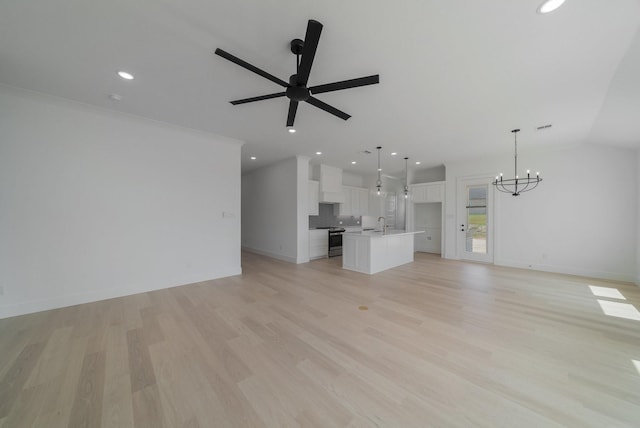 unfurnished living room featuring lofted ceiling, sink, ceiling fan with notable chandelier, and light hardwood / wood-style floors